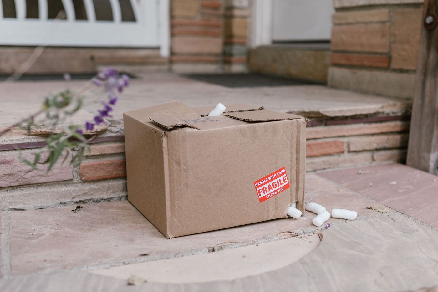 Carton de déménagement abîmé devant une porte