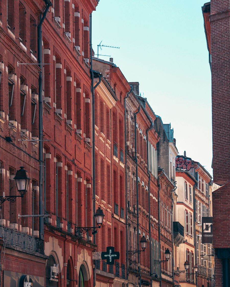 Rue de Toulouse bordée d'immeubles en brique rouge